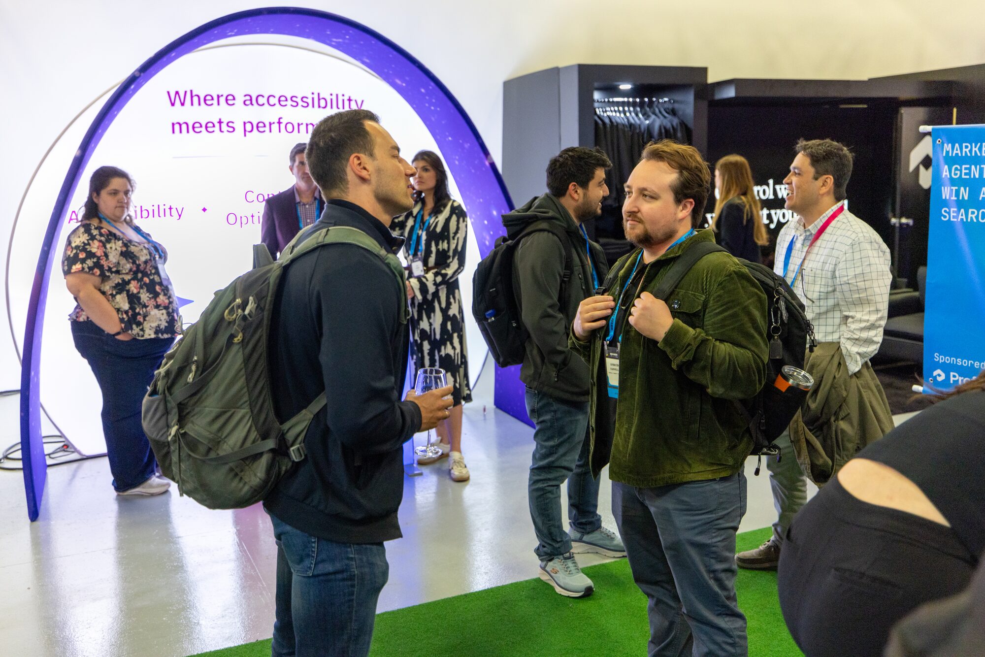 Attendees talking at a sponsor booth