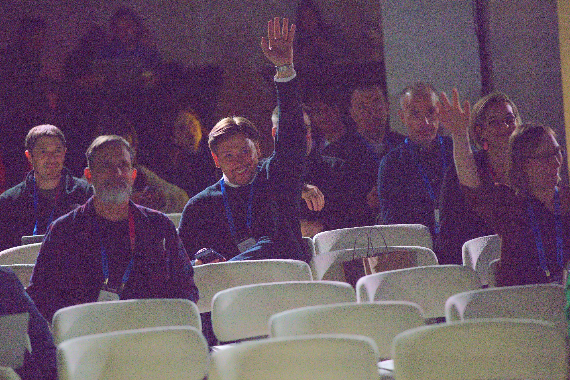 Audience members raising their hands during a session