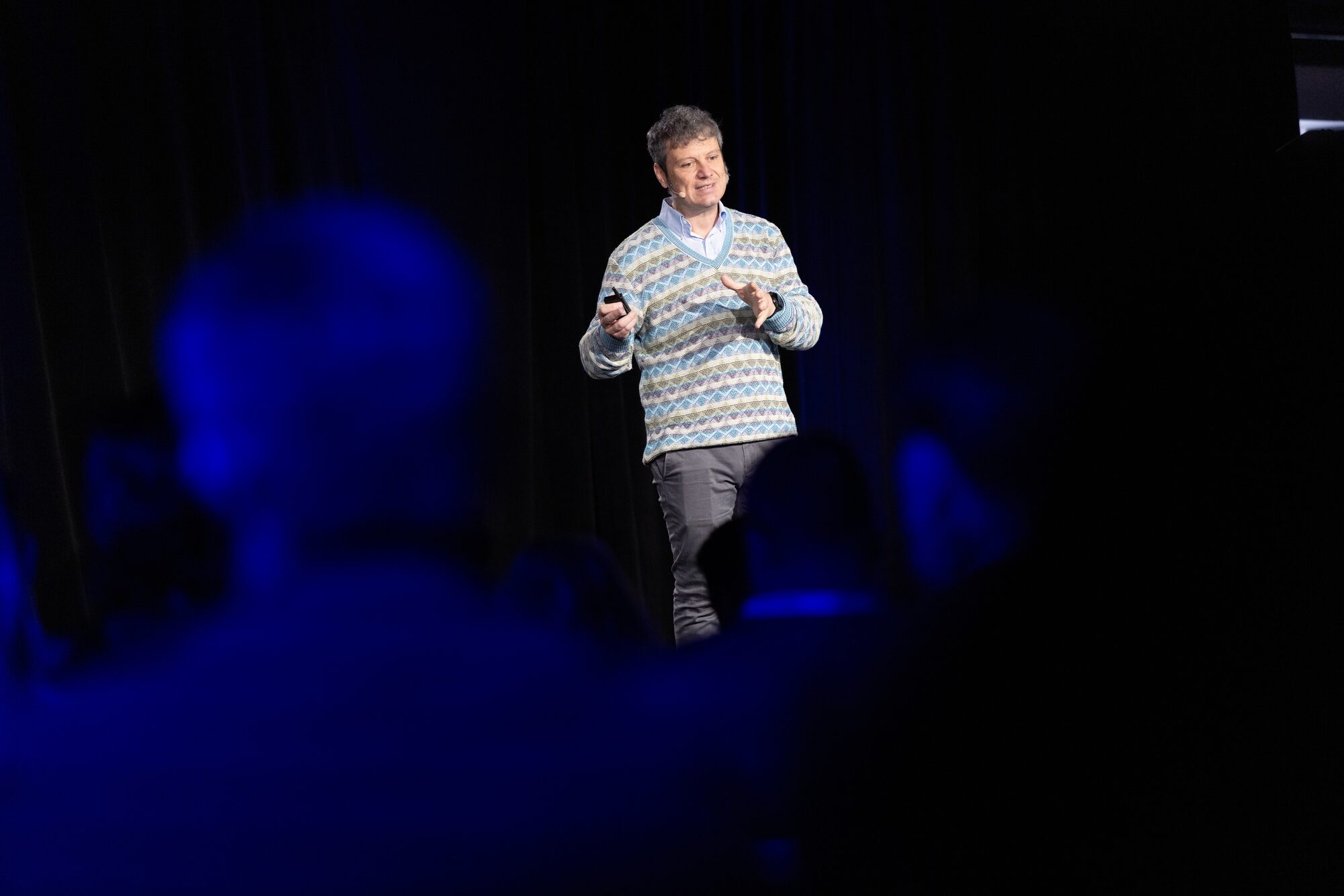 Keynote speaker on a spotlit stage